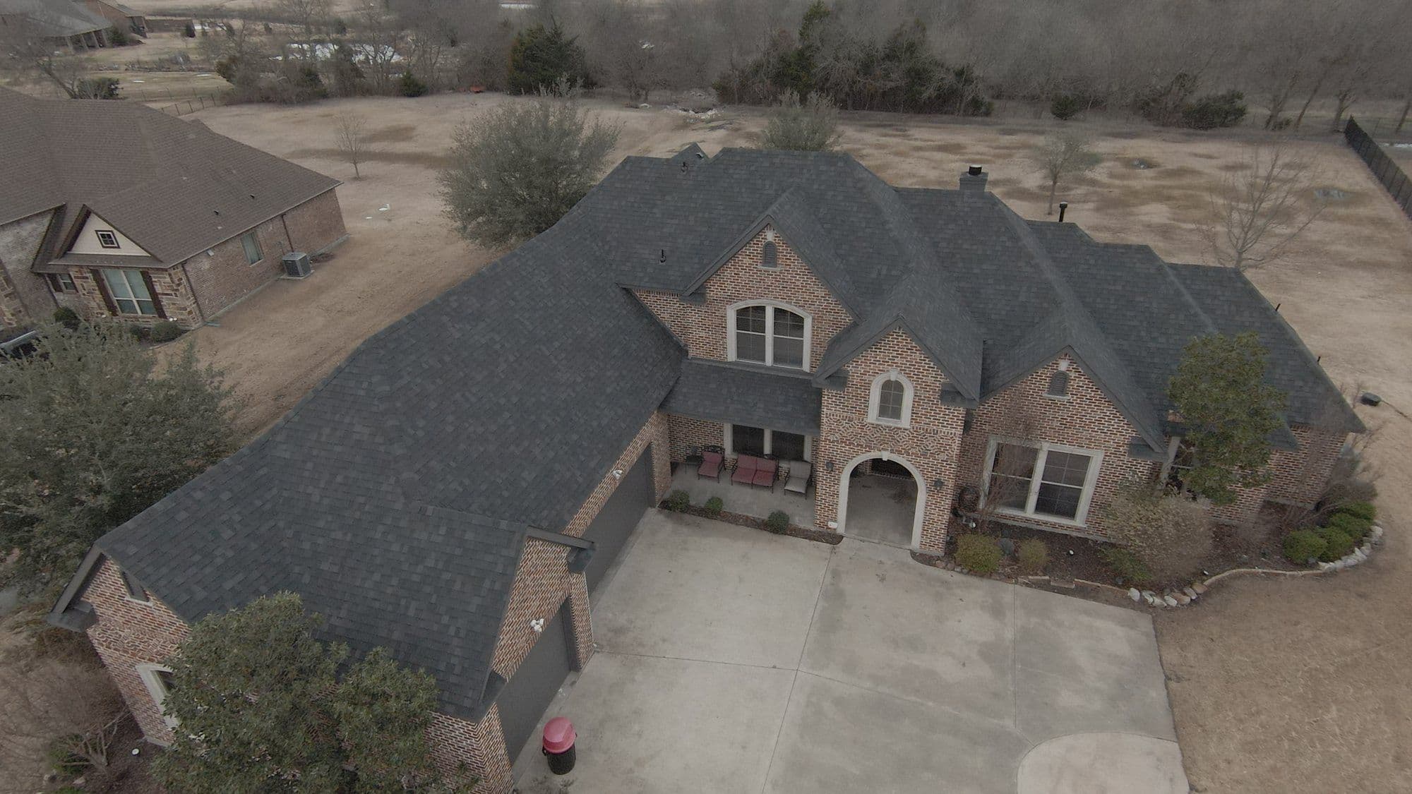 Finished roof on a brick two-story, front view, McLendon-Chisholm, TX