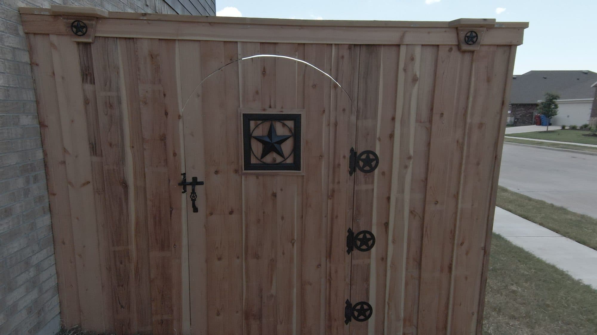 Cedar privacy fence gate with a Texas star and black hardware in Royse City, TX