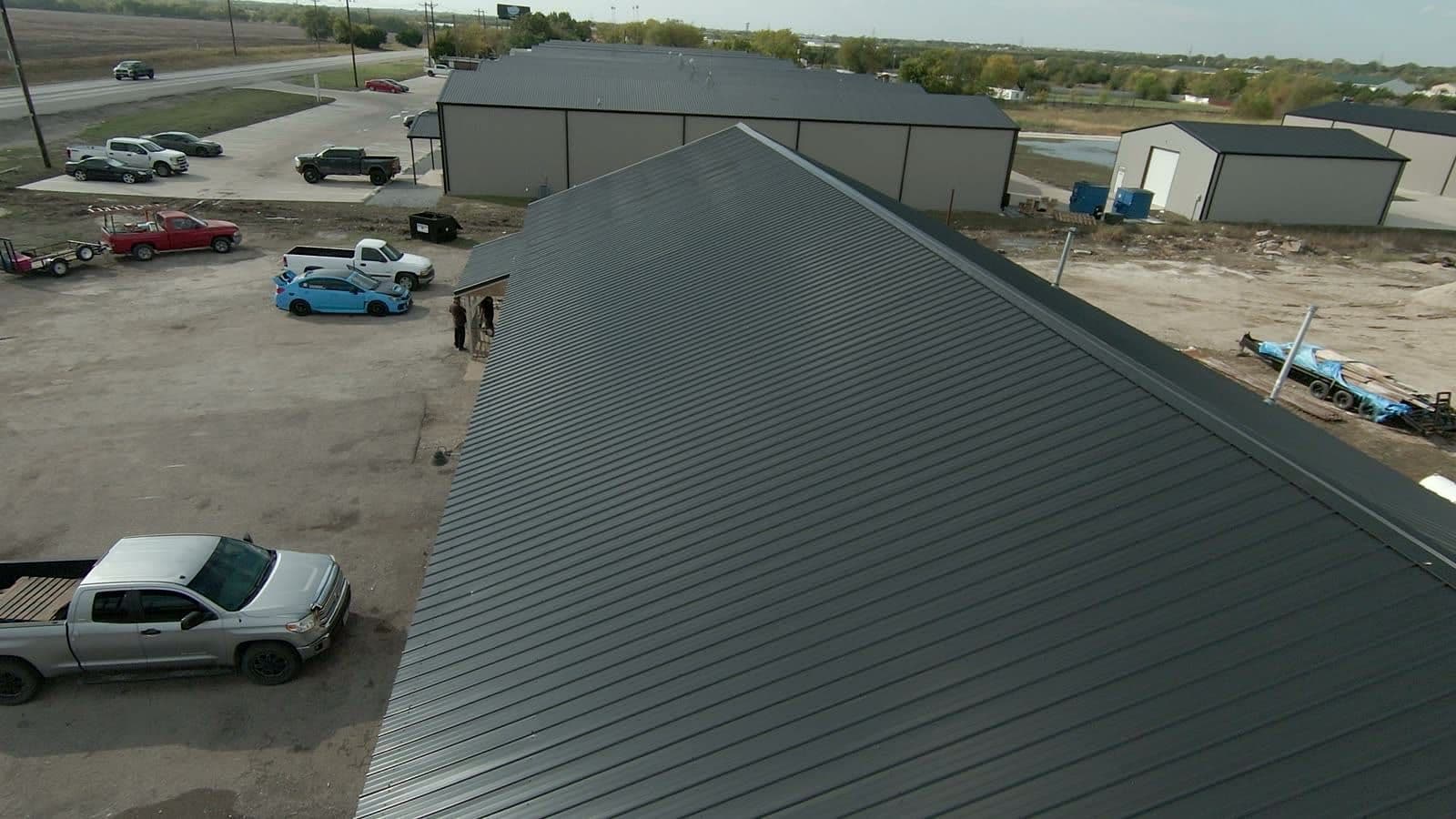 The same Royse City commercial building with a new dark standing-seam metal roof