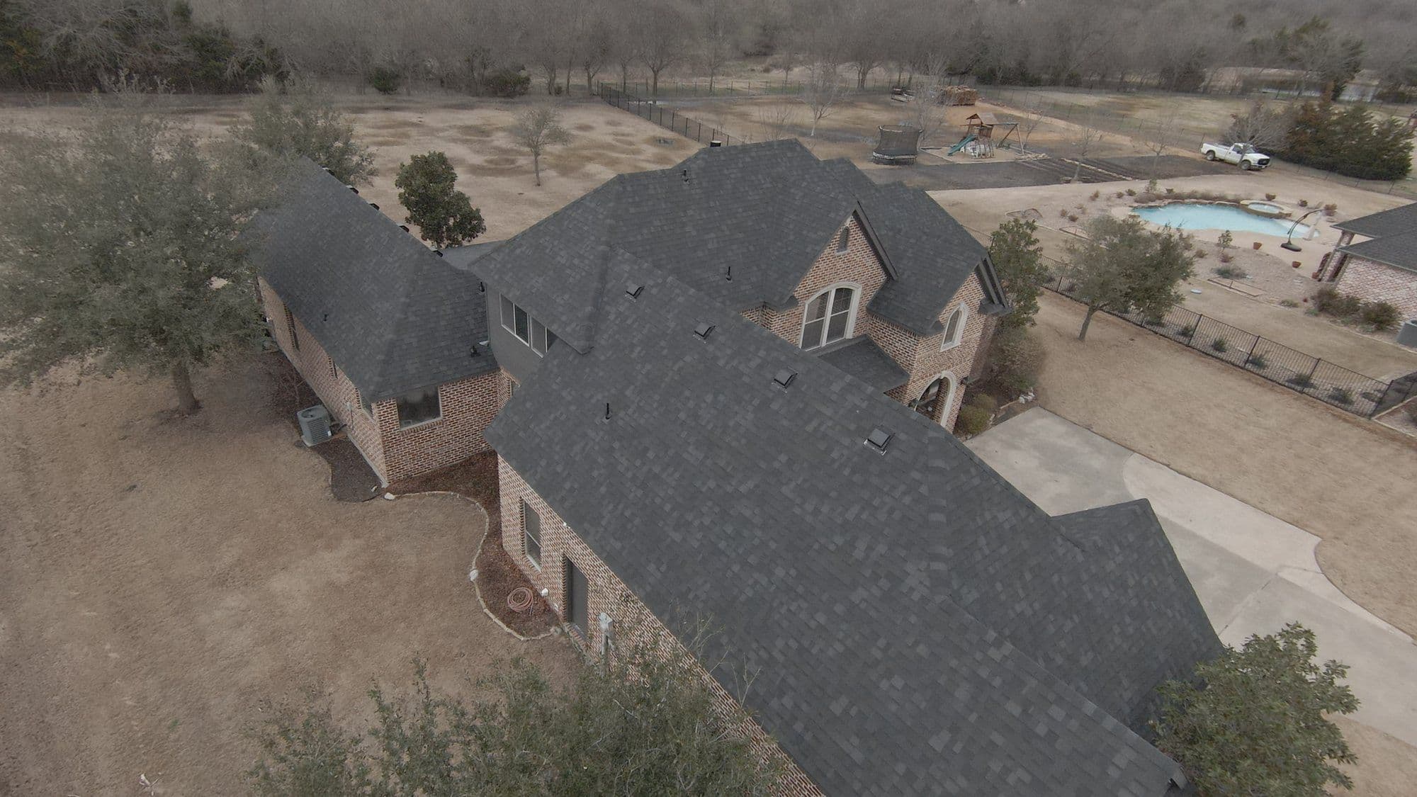 Finished roof on a brick two-story, side view, McLendon-Chisholm, TX