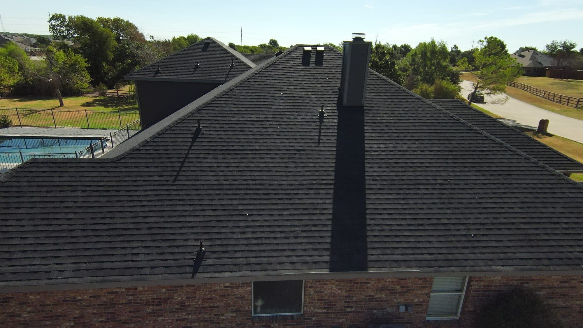 Ridge line and chimney flashing on a shingle roof in Royse City, TX