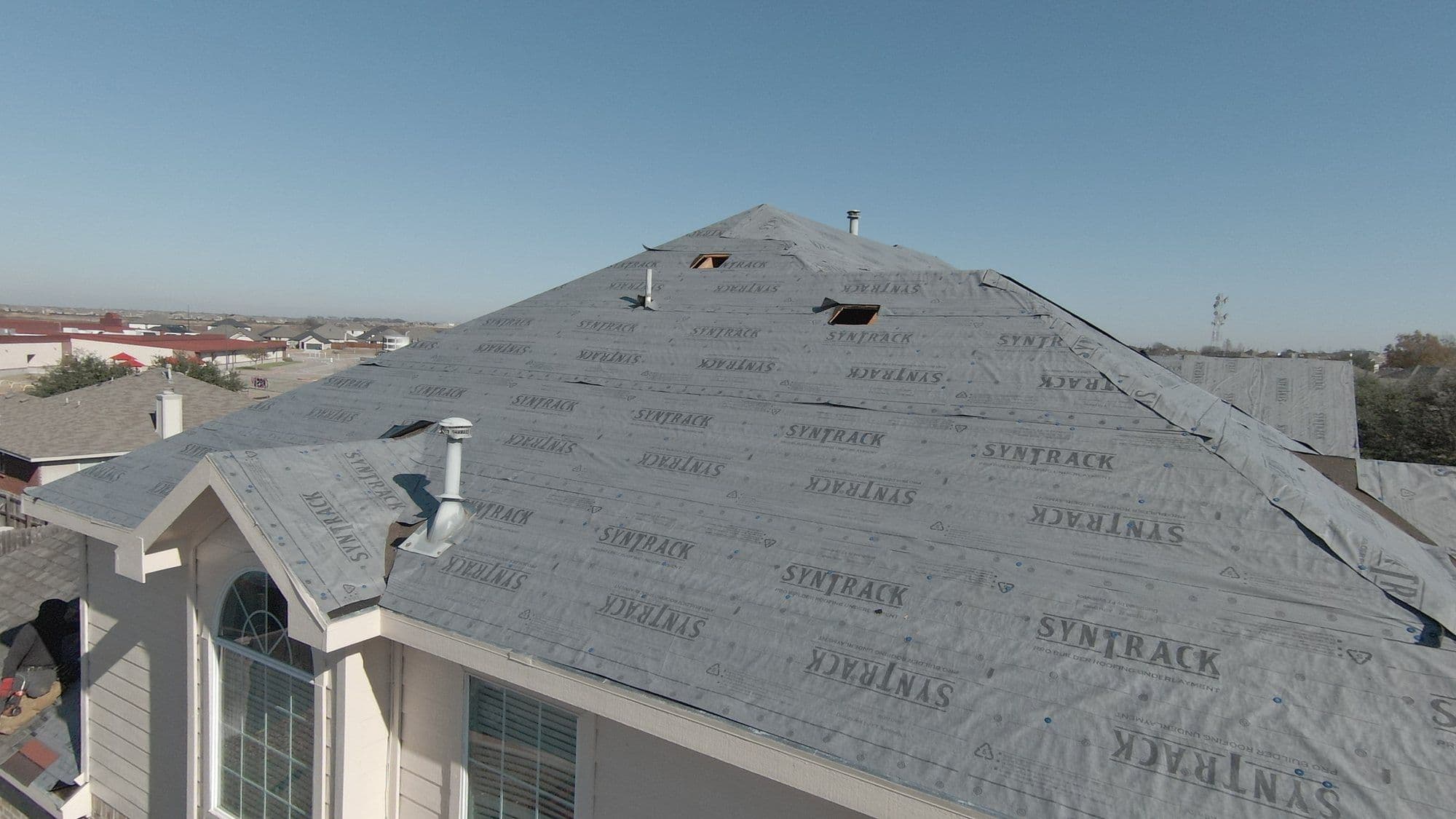 Synthetic underlayment going down during a roof replacement in Forney, TX
