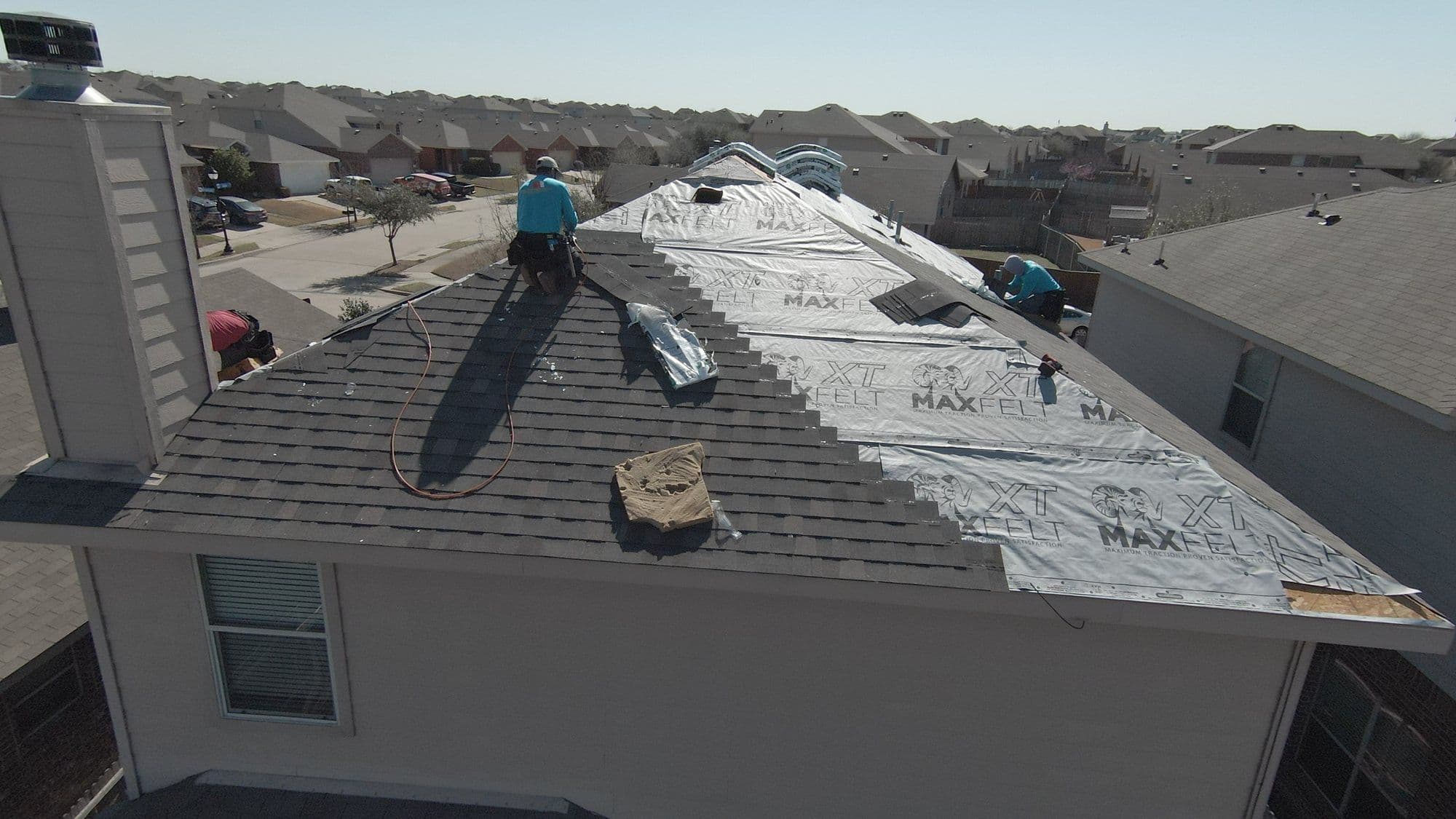 New shingles halfway up a roof slope during a re-roof in the Forney area
