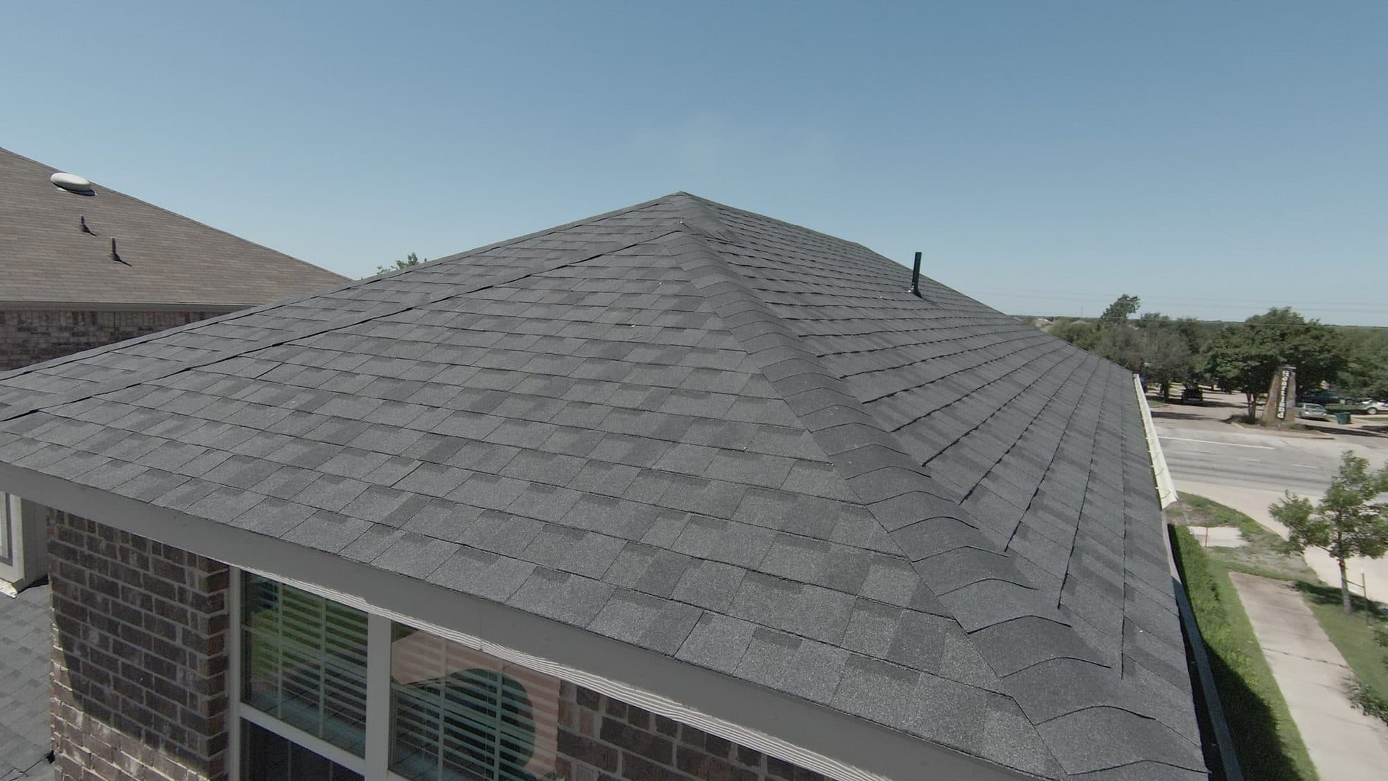 Finished hip roof with new architectural shingles on a brick home in Forney, TX